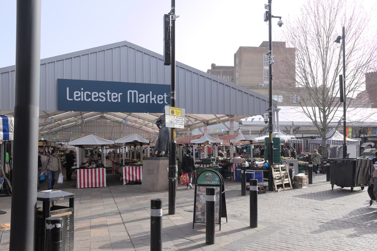 Stalls and shoppers under the Leicester Market canopy